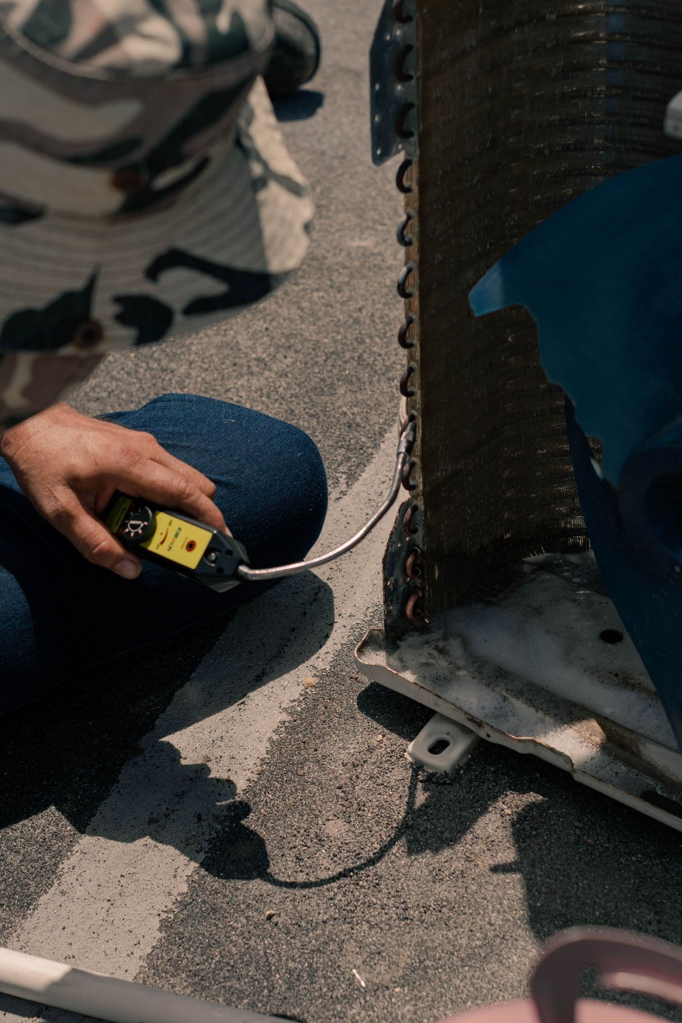 HVAC technician inspecting an outdoor air conditioning unit