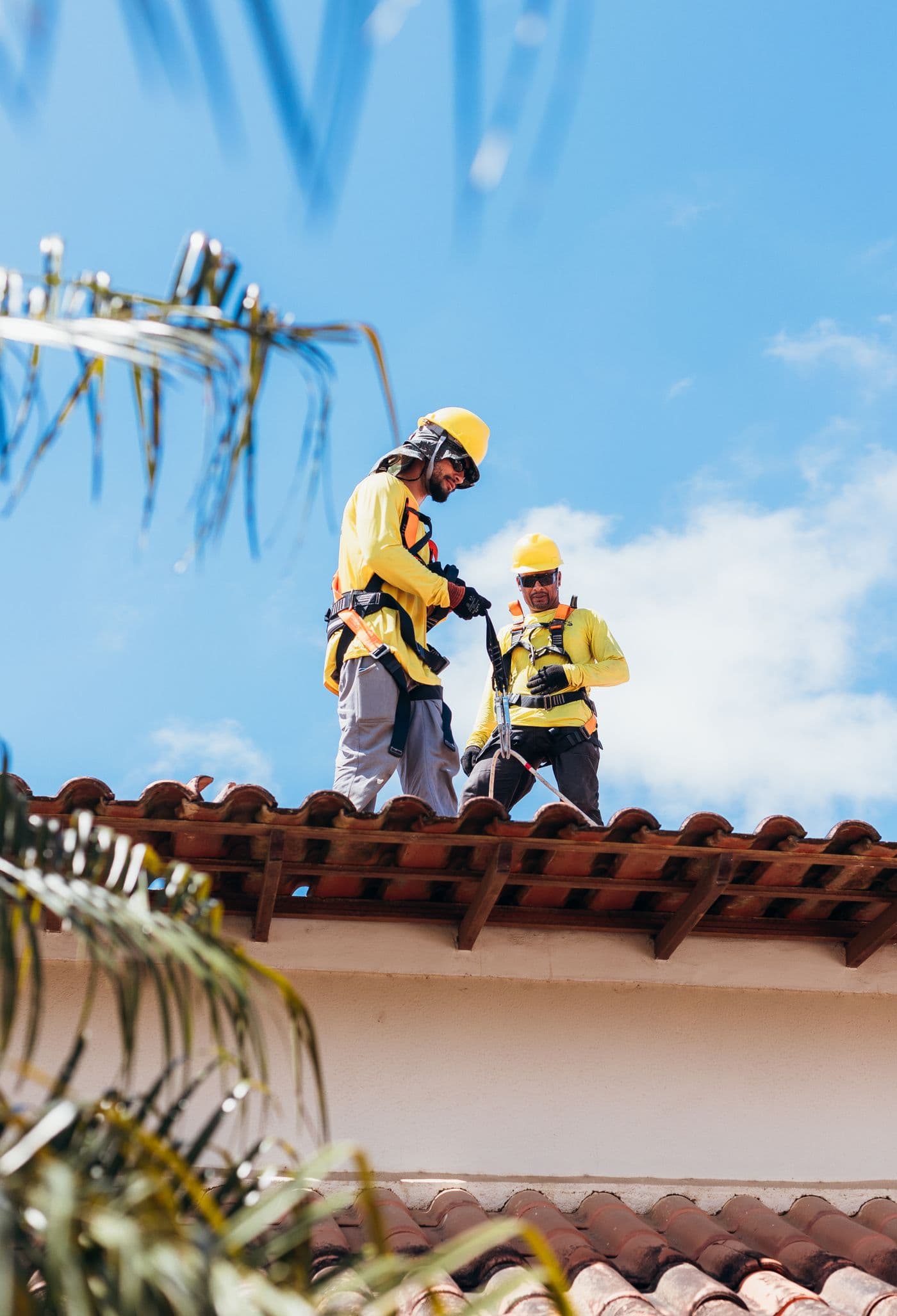 Roofing professionals working on a residential tiled roof